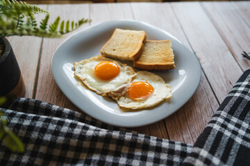 A top down and side view of eggs on the plate with toast bread on the side for breakfast clean meal healthy food 