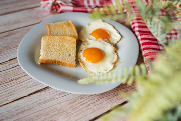 A top down and side view of eggs on the plate with toast bread on the side for breakfast clean meal healthy food 