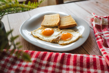 A top down and side view of eggs on the plate with toast bread on the side for breakfast clean meal healthy food 