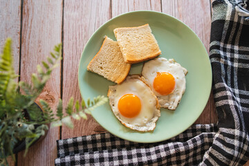 A top down and side view of eggs on the plate with toast bread on the side for breakfast clean meal healthy food 
