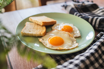 A top down and side view of eggs on the plate with toast bread on the side for breakfast clean meal healthy food 