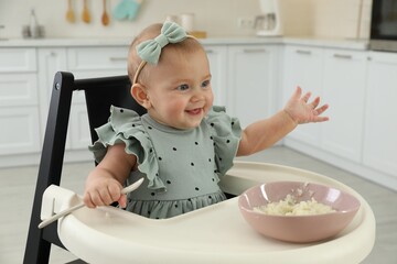 Cute little girl eating healthy food at home - obrazy, fototapety, plakaty