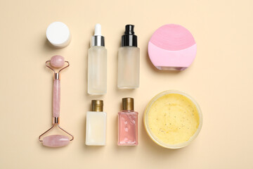Flat lay composition with skin care products and face roller on beige background