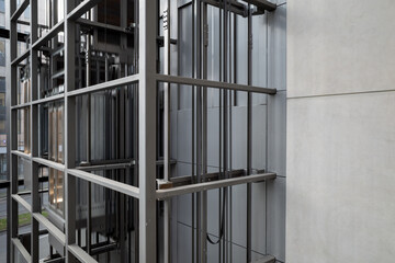 Exterior view at open system and modern industrial style of elevator with steel cage grid frame structure.