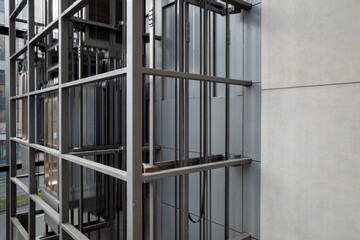 Exterior view at open system and modern industrial style of elevator with steel cage grid frame structure. © Peeradontax
