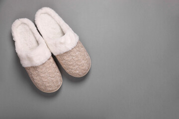 Pair of beautiful soft slippers on grey background, top view. Space for text