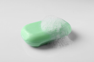 Soap with fluffy foam on white background