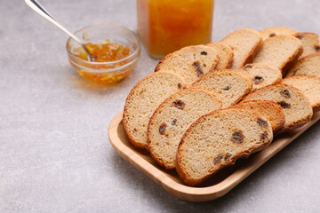 Sweet hard chuck crackers with raisins and jam on light grey table