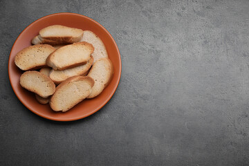 Plate of hard chuck crackers on grey table, top view. Space for text