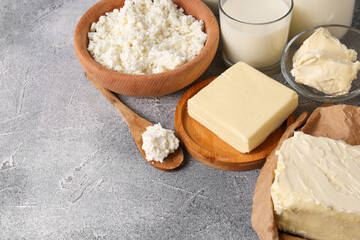 Tasty homemade butter and dairy products on grey table. Space for text