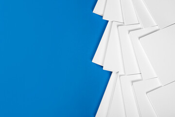 Many stacks of paper sheets on blue background, flat lay. Space for text