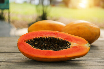 Fresh ripe papaya fruits on wooden table outdoors