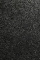 Texture of dark grey stone surface as background, closeup