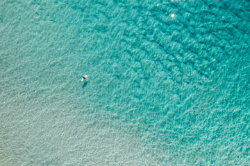 Aerial view of a surfer in the shallow water 