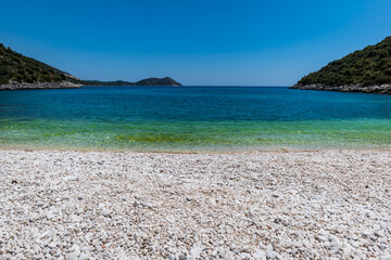 Obraz premium Beach landscape view by the Mediterranean sea in Antalya region, Turley. Antalya is a popular resort area in Turkey. 
