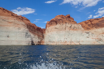Water spray from watercraft and colorful sandstone formations at Glen Canyon National Recreation Area, Arizona, USA