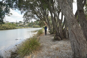 A woman walking around Hatea loop in Whangarei, New Zealand.