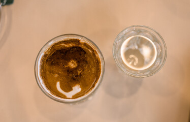 Dirty coffee iced latte freeze milk pour espresso shot in a cup of coffee on scale measurement wooden bar table cafe served with cool water