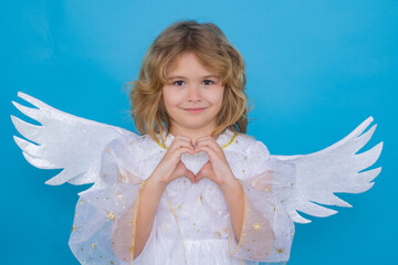 Little cute child at angel costume on isolated background. Kid with angel wings. Isolated studio shot. Funny angel.