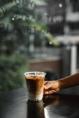 ice latte coffee in plastic glass on black table at cafe​
