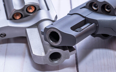 Two snub nose revolvers, a black 38 special and a stainless 357 magnum, both loaded with hollow...