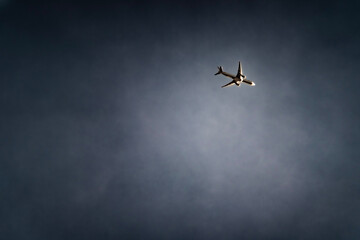 Airplane flying through dark clouds. 