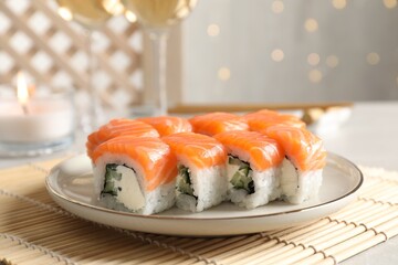 Tasty sushi rolls on table against blurred lights, closeup