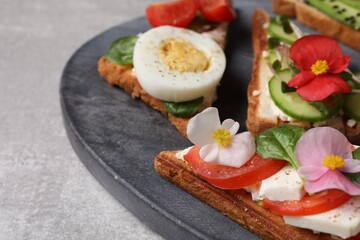 Different tasty sandwiches served on grey table, closeup