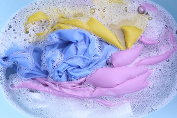 Color clothing in suds, top view. Hand washing laundry