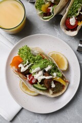 Delicious fresh vegan tacos served on light grey marble table, flat lay