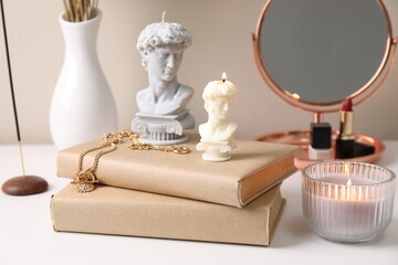 Beautiful David bust candles and books on white dressing table