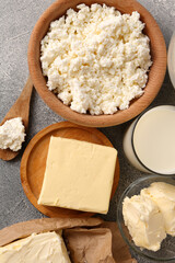 Tasty homemade butter and dairy products on grey table, flat lay