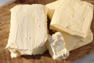 Tasty homemade butter on wooden board, closeup