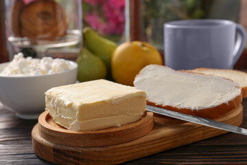 Tasty homemade butter, bread slices and tea on wooden table