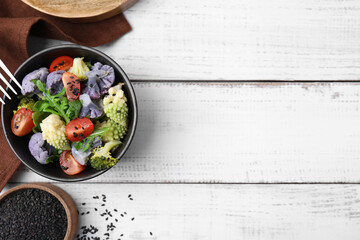 Delicious salad with cauliflower and tomato served on white wooden table, flat lay. Space for text