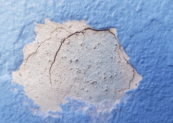 Close-up photo of cracked house wall repair marks.