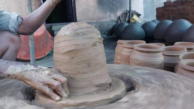 Hands of a potter creating an earthen jar. Potter making a clay pot on the pottery wheel in village India - Mitti Ka Mataka