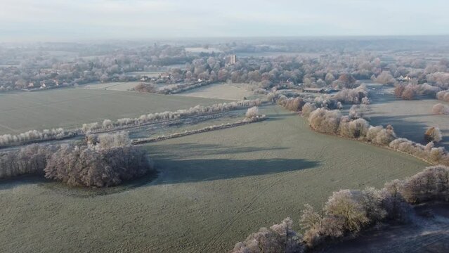Drone footage flying towards Dedham church and village in a hoar frost early in the morning.