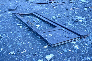 damaged wooden door frame and glass pieces on the street after missile attack in Kiev, Ukraine.
