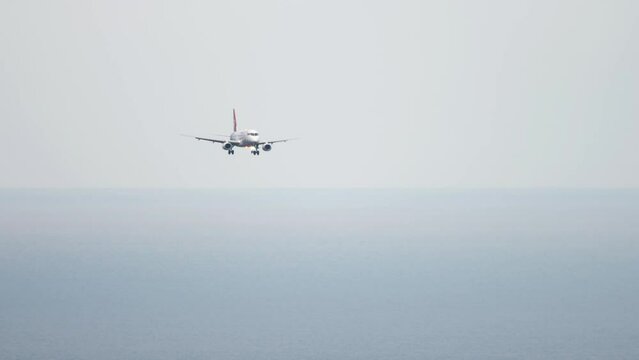 Long shot of civil jet airplane landing at Sochi International Airport. Tourism and travel concept