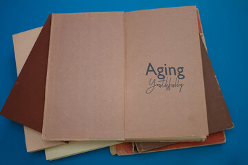 Aging Youthfully word in opened book with vintage, natural patterns old antique paper design.