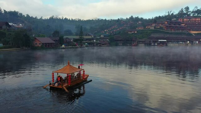 Asian woman wearing chinese traditional dress on a boat at Ban Rak Thai village, Mae hong son province.