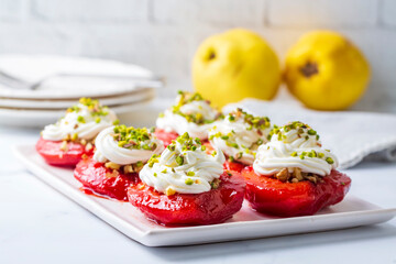 Traditional Turkish style quince dessert. The quince is cooked until soft, sherbet is poured on it, and served with cream and walnuts. It is one of the most popular Turkish desserts.(Ayva Tatlisi)
