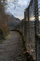 Trail running beside chain link fence