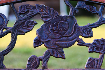 Vintage bench with flower design and blurred grass in the background 