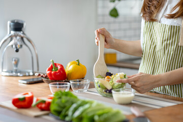 Portrait of attractive asian japanese woman in kitchen at home, young girl browsing website on tutor cooking class and doing for kitchen, cutting vegetables, cooking, cooking concept.