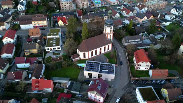 Circle Drone shot of Martinskirche in the small town Lahr, Schwarzwald, Germany. houses and church in german village,