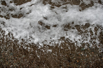 sea, foamy wave on a pebble beach.