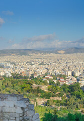 View in Athens of the Temple of Hephaestus among the greenery and buildings in the distance in a vertical format