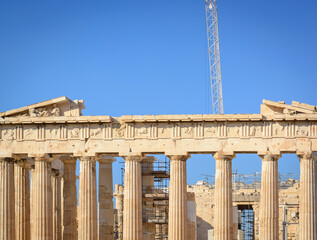 View of part of the Doric columns of the Acropolis and the crane against the blue sky in Athens